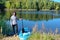 Active woman with SUP board near beautiful lake, nature on background, stand up paddling water adventure outdoors