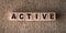 Active - word written on wooden blocks over brown background