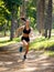 Active young brunette woman running in park, summer, healthy, perfect tone body. Workout outside. Lifestyle concept