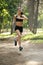 Active young brunette woman running single in park, summer, healthy, perfect tone body, fit. Workout outside