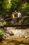 Active young cople hiking on a wooden brifge over mountain creek