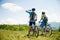 ACTIVE Young couple biking on a forest road in mountain on a spring day