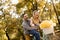 Active young couple enjoying riding bicycle in golden autumn par