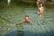 Active young couple plays in shallow water on a hot summer morning