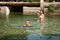 Active young couple plays in shallow water on a hot summer morning