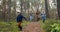 active young family with children having fun outdoors. running on forest trail