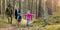 Active young family with two children spend time together on a walk in forest. copy space