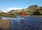 Active young hiker woman crossing river and enjoying the mountain view on adventure active freedom emotions vacations outdoor