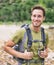 Active young man portrait hiking outdoors. Young male hiker smiling happy wearing backpack for backpacking camping