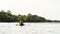 Active young people paddling together on a river surrounded by summer nature on a weekend