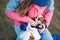 Active young woman dressing her little chihuahua dog in animal warm clothes