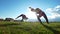 Active young women performs acrobatic stunts on the grass at summer sunset