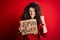 Activist with curly hair and piercing protesting holding poster with woman power message annoyed and frustrated shouting with