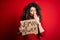 Activist with curly hair and piercing protesting holding poster with woman power message cover mouth with hand shocked with shame