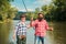 Activity and hobby. Set up rod with hook line sinker. Two male friends dressed in shirts fishing together with net and