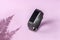 Activity smart tracker on light pink background. Black fitness health watch with fern shadow, sport bracelet
