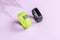 Activity smart trackers on light pink background. Black and green fitness health watch with fern shadow, sport bracelets