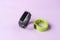 Activity smart trackers on light pink background. Black and green fitness health watch, sport bracelets