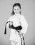 Activity and sport. Strong and confident kid. Girl little child in white kimono with belt. Karate fighter ready to fight