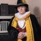 Actor dressed historical costume in interior of old theater.