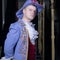 Actor dressed historical costume in interior of old theater.