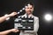 Actor performing while second assistant camera holding clapperboard on black background