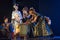 Actors in traditional costumes pouring sake from the barrel on the stage