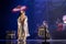 Actress in traditional kimono on the dark stage with umbrella and taiko drummers