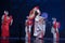 Actresses in traditional white and red kimono and fox masks dancing with umbrella and fans