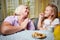 Adalt mother and her young daughter in a kitchen with pancakes