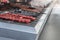 Adana kebabs with red tomatoes on a barbecue in a food festival, close up