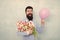 Add holiday cheer with this festive bouquet. Bearded man hold tulips and balloon. Holiday celebration. Happy valentines