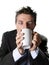 Addict business man in suit and tie drinking cup of coffee anxious and crazy in caffeine addiction