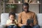 Addicted of gadgets african dad and son sitting on couch