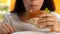 Addicted to fast food woman chewing burger closeup, unhealthy nutrition appetite