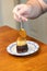 Adding caramel sauce to chocolate cake slice