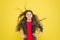 Adding care to her hair. Adorable small girl child happy smiling with long wavy brunette hair on yellow background