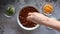 Adding cheese to a bowl of chilli with beans on a concrete background