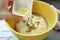 Adding chopped fresh garlic onto kneaded dough for baking Focaccia bread
