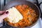 Adding grated celery root into frying pan