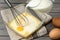 Adding milk to whisked eggs at wooden table