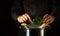 Adding parsley with the chef hands to a pan of boiling chicken legs. The concept of preparing a side dish or rich soup in a