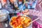 Adding tomato puree to a saucepan of cooking vegetables