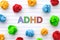 ADHD. Abbreviation ADHD on notebook sheet with some colorful crumpled paper balls around it