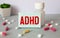 ADHD. Abbreviation ADHD on notebook sheet with some crumpled paper balls on it. Close up.