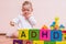 ADHD concept. Baby is playing with colorful cubes with letters