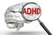 Adhd word on magnifying glass and human brain