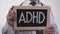 ADHD written on blackboard in therapist hands, psychiatric mental disorder