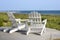 Adirondack chairs overlooking beach.