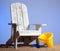 Adirondack chairs on sand with blue sky